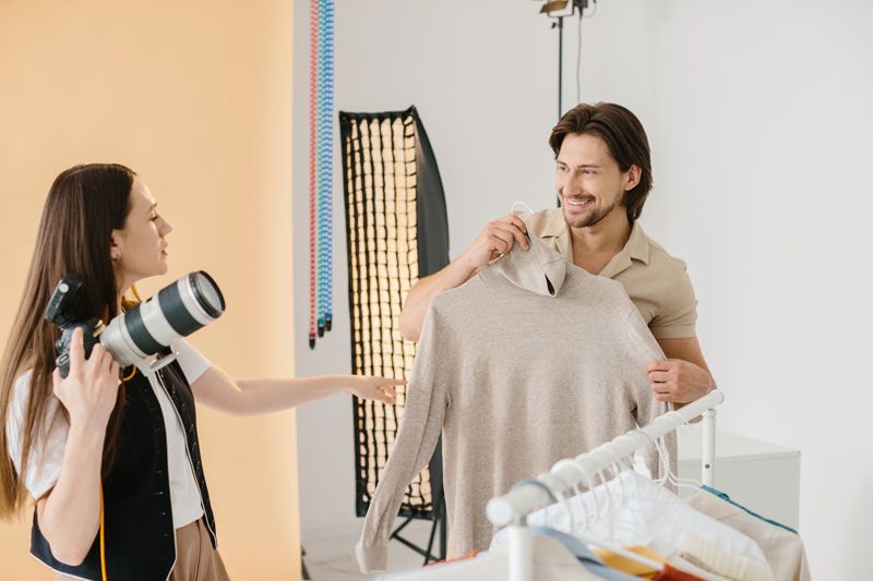 Kledingstylist en fotograaf bespreken de kledingstijl bij een fotoshoot