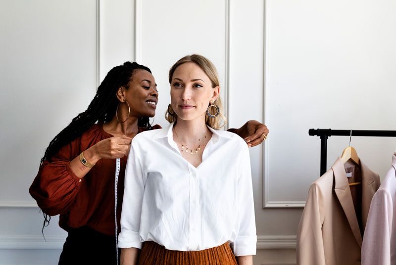 Kledingstylist meet kleding op bij een model van Shootz