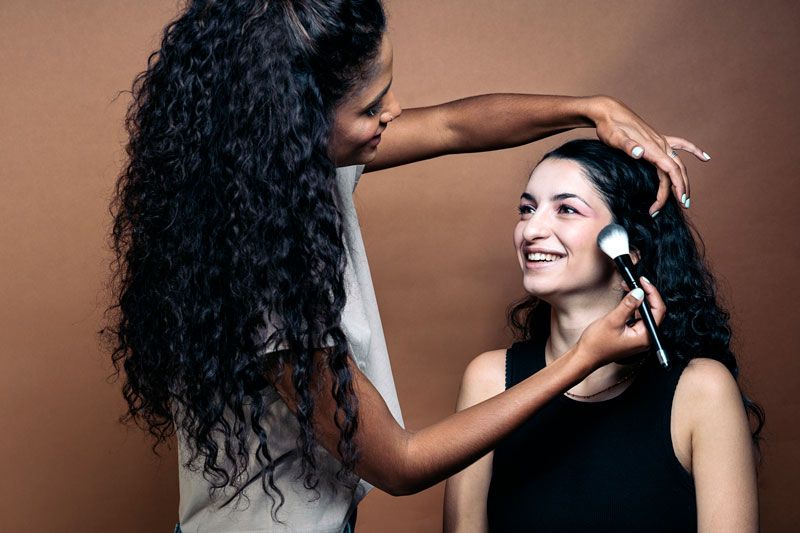 Visagiste brengt make-up aan bij model van Shootz